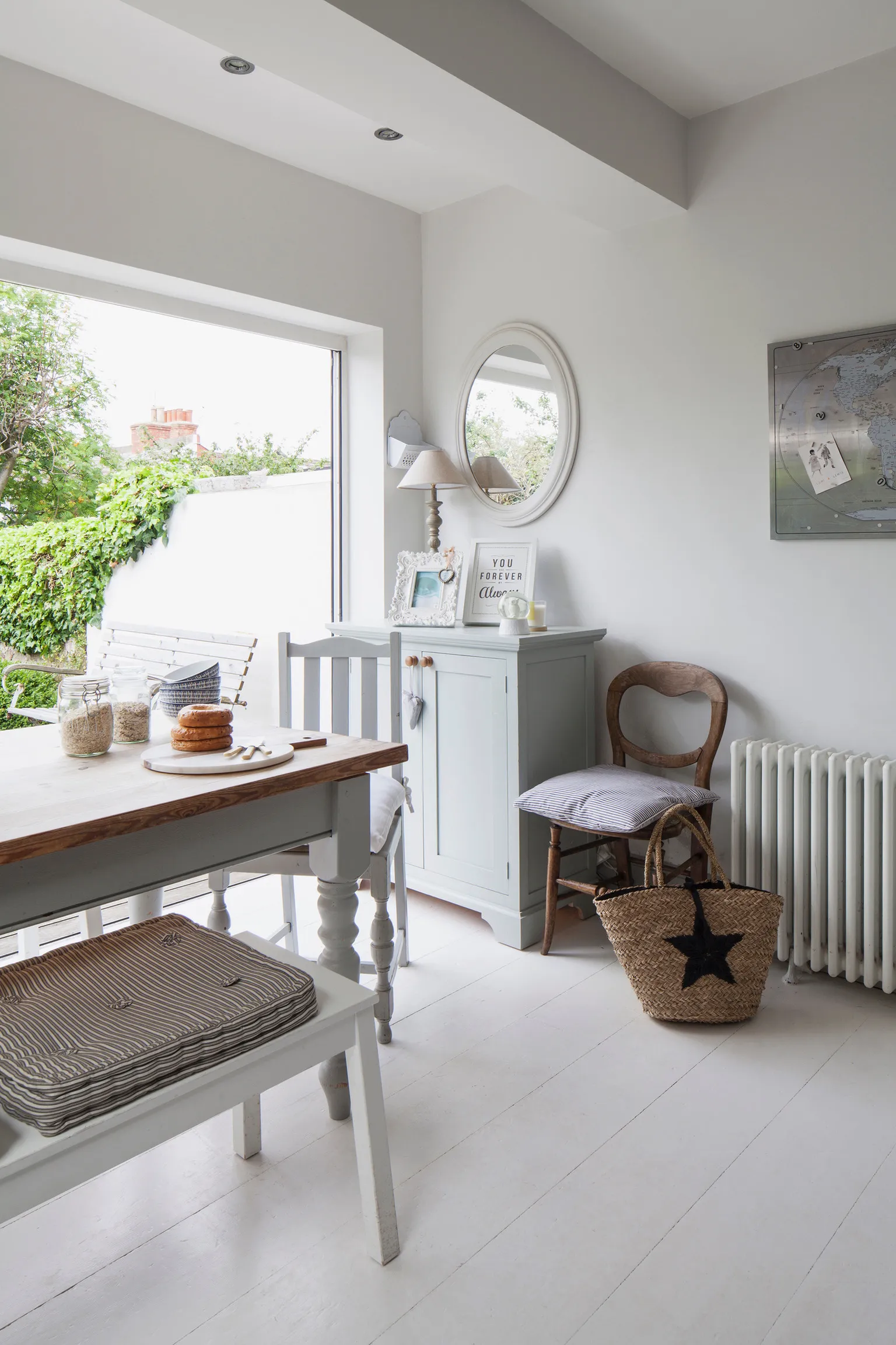 A white room with a table, chair, and radiator.