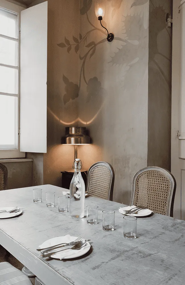 A dining room with a table and chairs.